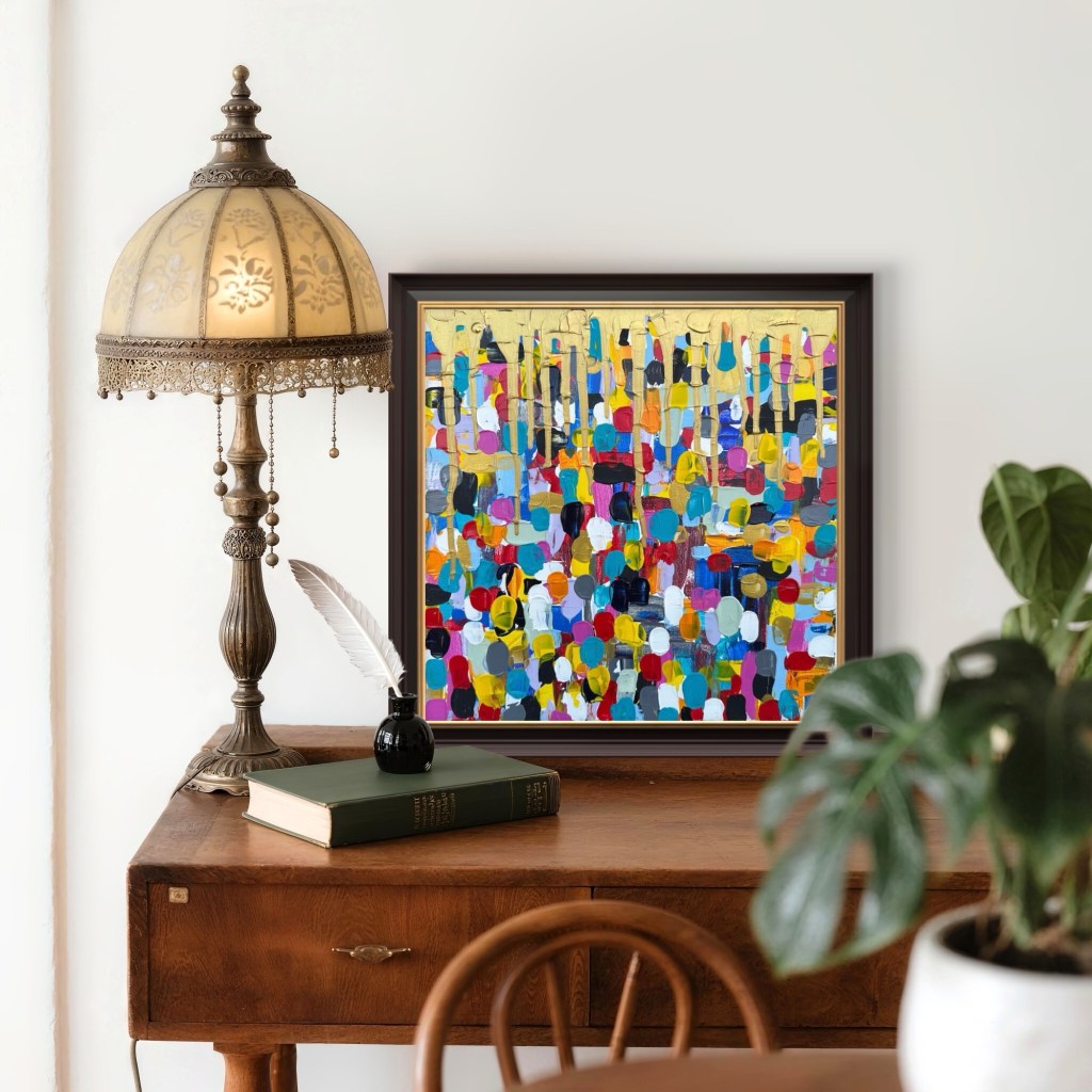 Dipinto astratto su tela 40x40 cm, oro e acrilico, intitolato People di Elisabetta Scaglia. L’opera presenta una moltitudine di pennellate vivaci in colori accesi – blu, rosso, giallo, turchese, nero e bianco – che si intrecciano in verticale sotto colature dorate. Esposta in un’elegante cornice scura, accanto a una lampada vintage e libri, dona energia e armonia all’ambiente.